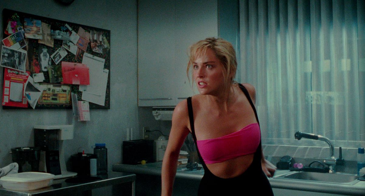 Sharon Stone looks angry in a pink top and leotard in Total Recall