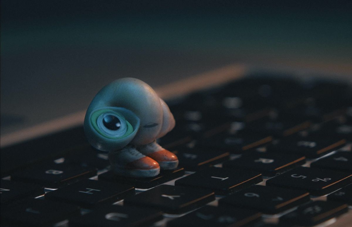 Marcel the Shell, a tiny shell voiced by Jenny Slate, stands on a keyboard in the film Marcel the Shell With Shoes On