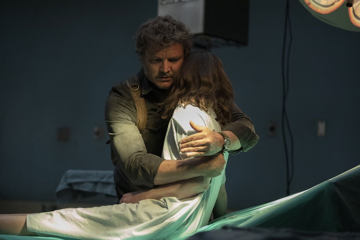 Joel lifts Ellie to his shoulder from a hospital operating table in a scene from HBO’s The Last of Us.