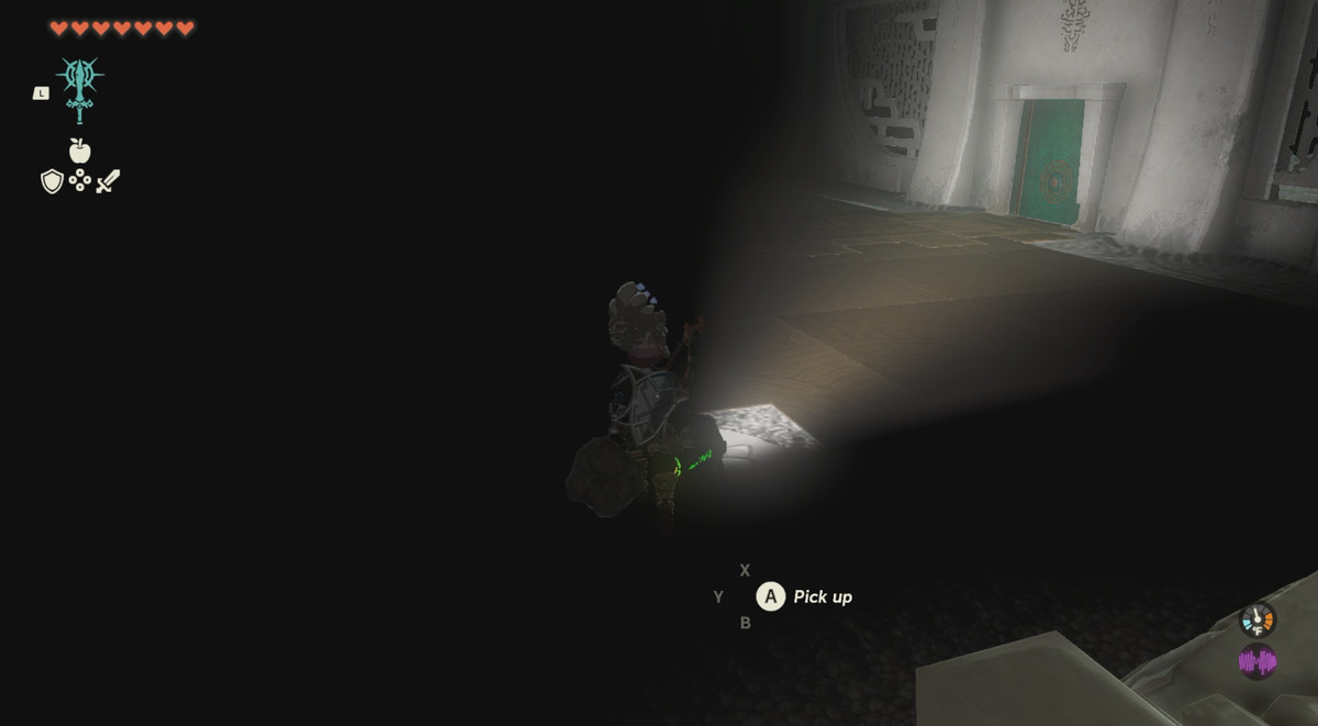 A dark place, with Link pointing a flashlight at a green door in Zelda: Tears of the Kingdom